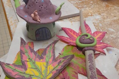 Des objets en céramique : en haut à gauche une maisonnette, à droite une baguette magique et en dessous de la maison une feuille d'automne. - Agrandir l'image, fenêtre modale