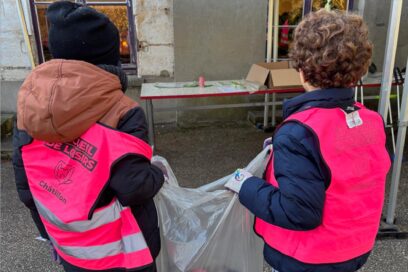Deux enfants tiennent un sac poubelle. Ils portent le gilet rose des accueils de loisir châtillonnais. - Agrandir l'image, fenêtre modale