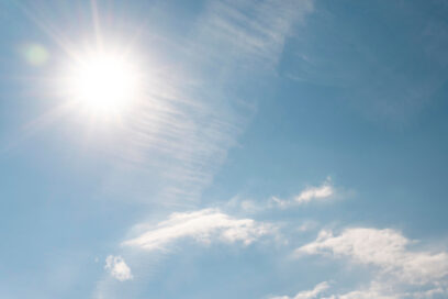 Soleil éclatant dans un ciel bleu légèrement nuageux, illustrant une forte chaleur et un épisode estival. - Agrandir l'image, fenêtre modale