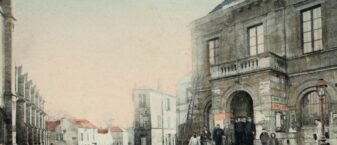 ue ancienne du centre de Châtillon. Au premier plan, une rue pavée avec deux réverbères mène à l’hôtel de ville. Plusieurs habitants, dont des enfants, se tiennent devant le bâtiment municipal et le long de la rue. L’image, colorisée et légèrement patinée par le temps, témoigne de l’ambiance et de l’architecture de la ville d’autrefois.