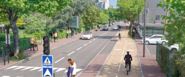 Vue d’une avenue urbaine réaménagée et bordée d’arbres. La chaussée accueille la circulation automobile, tandis qu’une piste cyclable bidirectionnelle protégée longe la voie. Plusieurs cyclistes, piétons et véhicules sont visibles. Des passages piétons sécurisés, une signalisation dédiée et des espaces végétalisés contribuent à un cadre de vie apaisé et favorable aux mobilités douces.