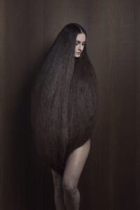 Isabelle Chapuis, autoportrait de l'artiste. Elle est dans un cocon fait de ses cheveux. - Agrandir l'image, fenêtre modale