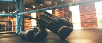 Gants de boxe noirs posés sur un ring de boxe