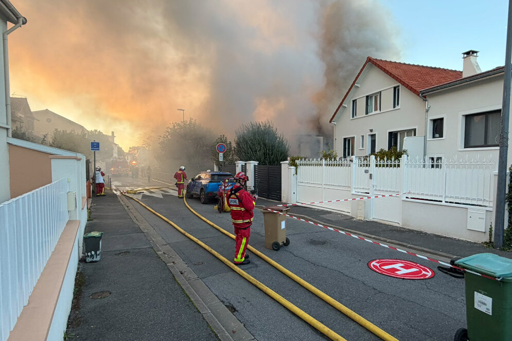 Des sapeurs-pompiers interviennent dans une rue de Châtillon, envahie par une épaisse fumée à la suite d’un incendie dans l’ancienne école Jean-Jaurès. Des tuyaux d’incendie sont déployés sur la chaussée et un périmètre de sécurité a été installé.