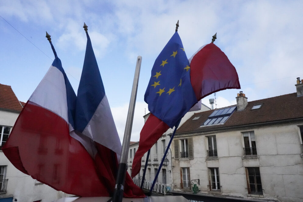 Drapeaux français, européen et tricolore flottant devant la façade de l’Hôtel de Ville.