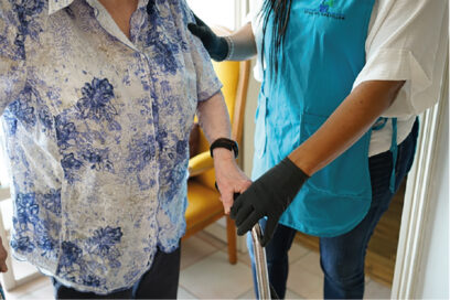 Une agent du CCAS de Châtillon aide un senior à marcher. - Agrandir l'image, fenêtre modale