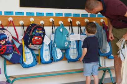Un enfant et son papa devant les sacs de la rentrée scolaire, dans une école de la ville. - Agrandir l'image, fenêtre modale