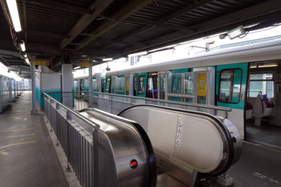 Photo du quai de station "Châtillon-Montrouge" avec au centre un escalier mécanique et à droite un rame à l'arrêt. - Agrandir l'image, fenêtre modale